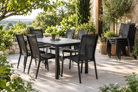 Six chaises de jardin noires en textilène autour d’une table sur une terrasse végétalisée