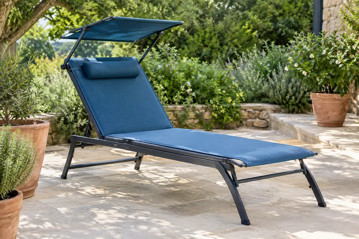 Bain de soleil bleu pliable avec pare-soleil réglable, coussin et appuie-tête dans un jardin