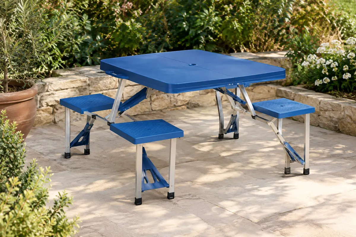 Table de camping bleue avec quatre places intégrées, installée sur une terrasse de jardin végétalisée