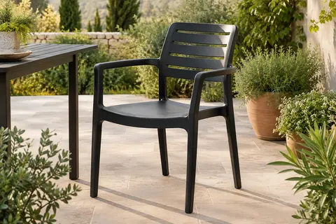Chaise de jardin noire en polypropylène avec accoudoirs, installée sur une terrasse végétalisée.