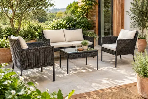 Salon de jardin en polyrotin noir avec canapé, deux chaises, coussins crème et table à plateau de verre