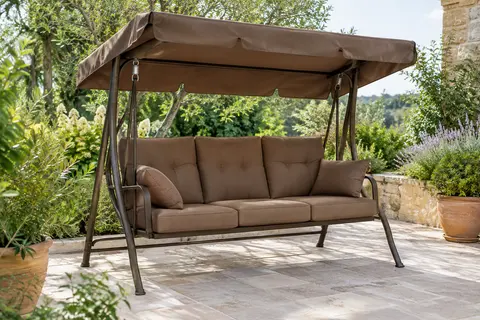 Balancelle de jardin marron avec coussins rembourrés et auvent inclinable, installée sur une terrasse végétalisée.