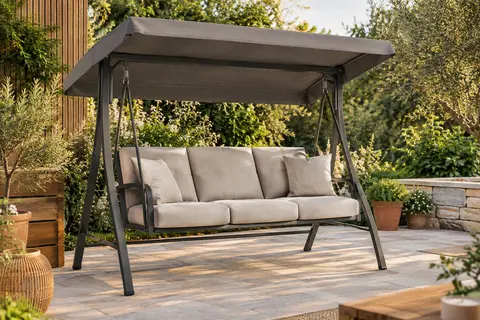 Balancelle de jardin anthracite avec matelas, deux oreillers et toit réglable sur une terrasse végétalisée