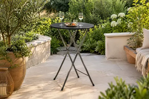 Table mange-debout Oxeo à plateau rond noir installée sur une terrasse végétalisée
