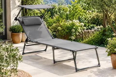 Chaise longue TecTake pliable en toile grise, installée sur une terrasse végétalisée avec pare-soleil relevé.