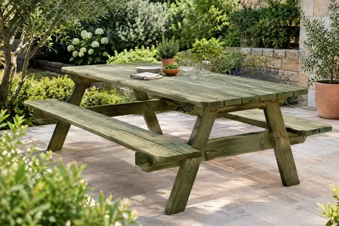Table de pique-nique en pin imprégné vert avec grand plateau et deux bancs dans un jardin